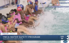 Kids splashing on the side of the pool for water safety swim lessons