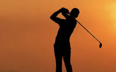 golfer swinging in the sunset