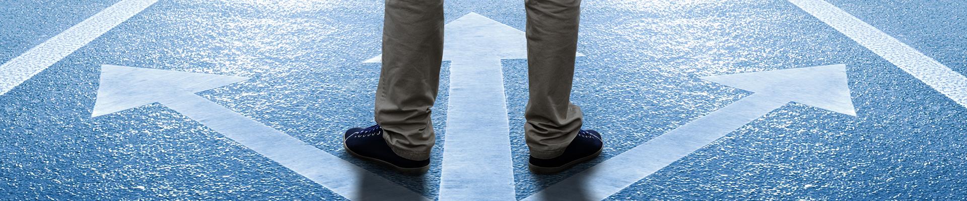 Feet stand at a crossroads, arrows pointing in 3 directions