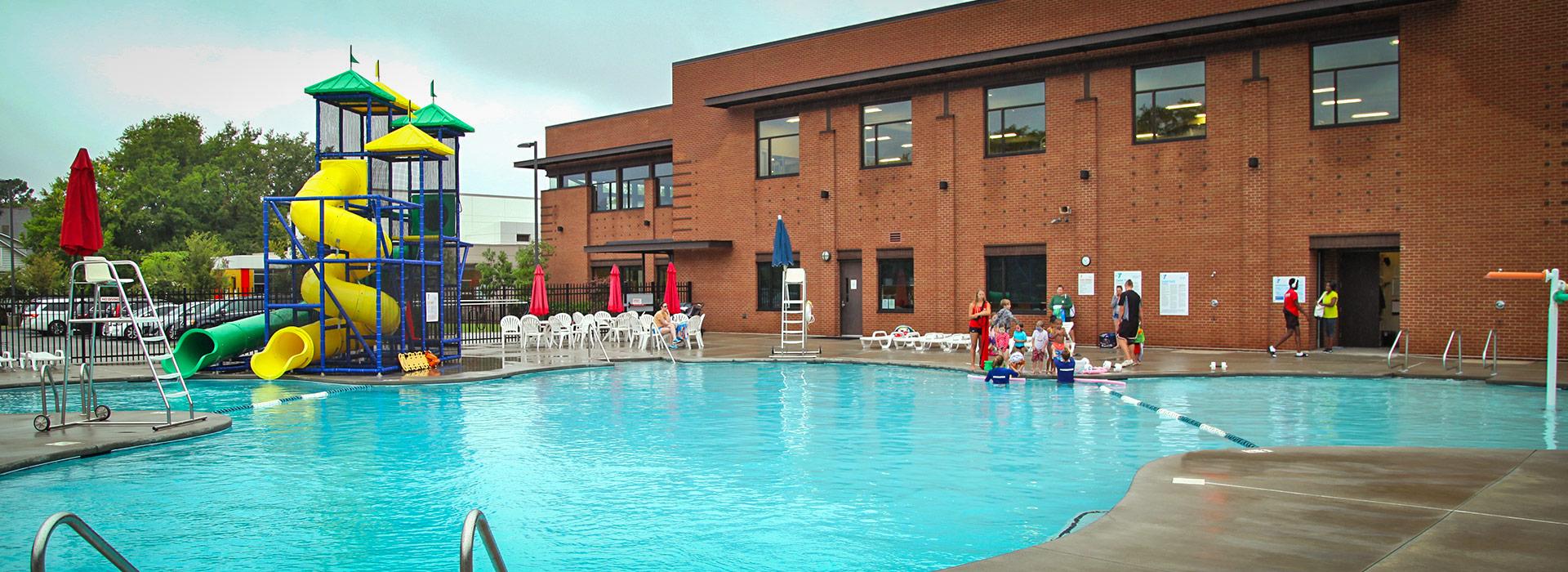 Outdoor pool with splash toys and water slides at the YMCA on Granby