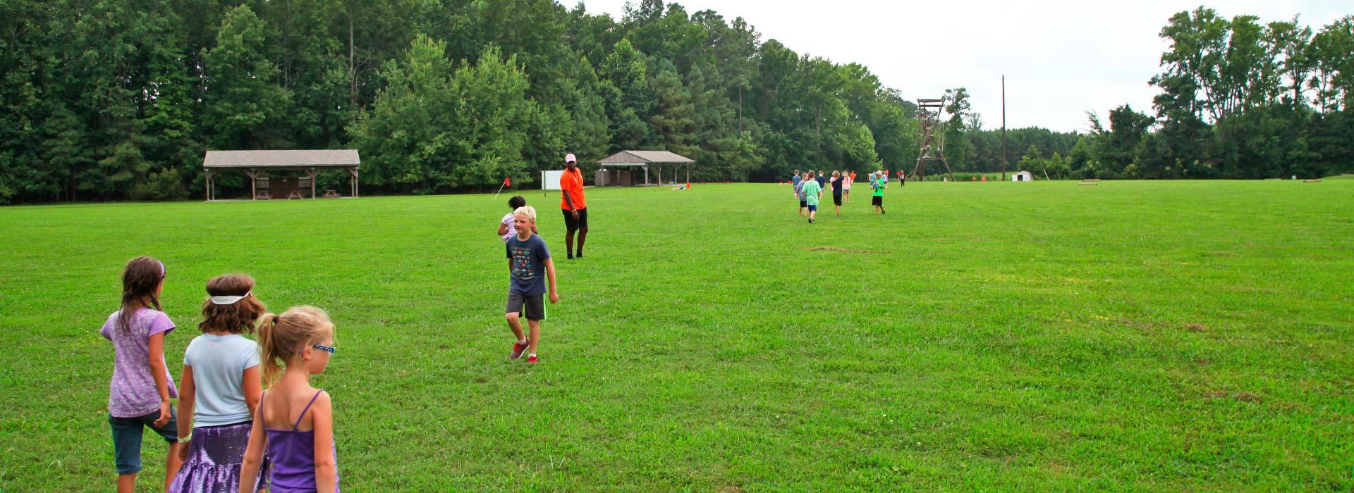 Campers walking across sports field at YMCA Camp Arrowhead in Suffolk, Virginia