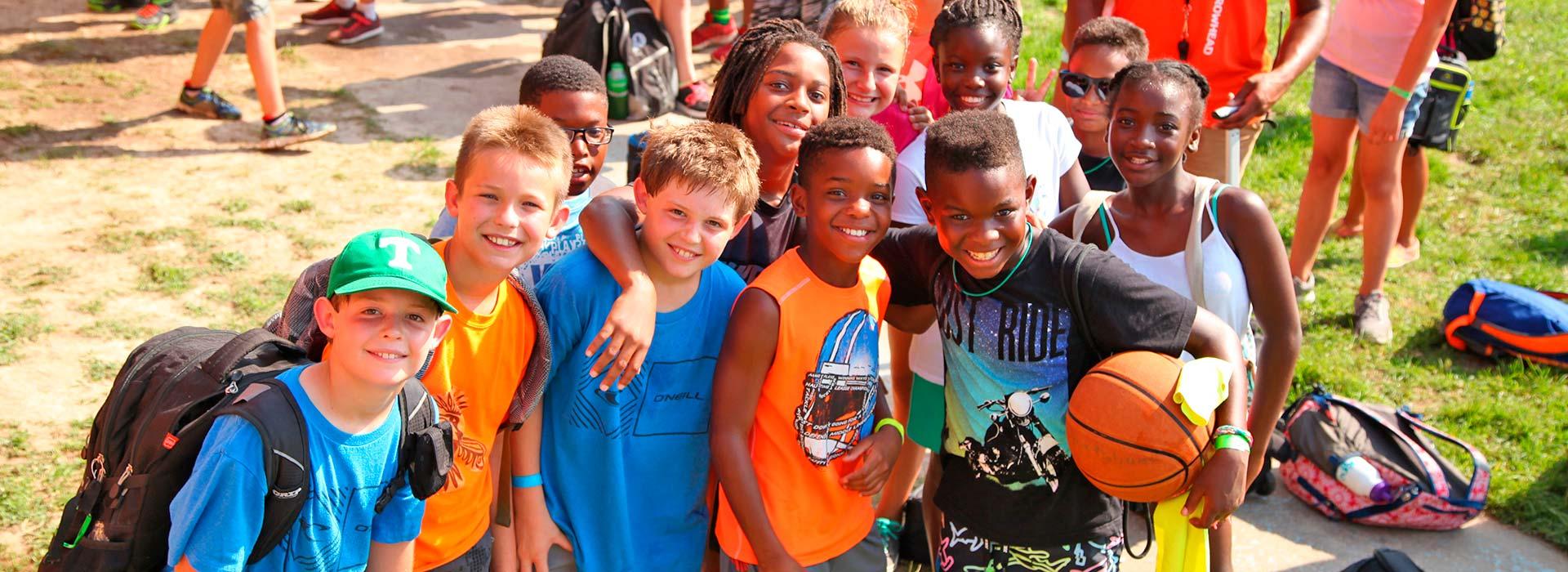 Group of campers with basketball and backpacks at YMCA Camp Arrowhead in Suffolk, Virginia