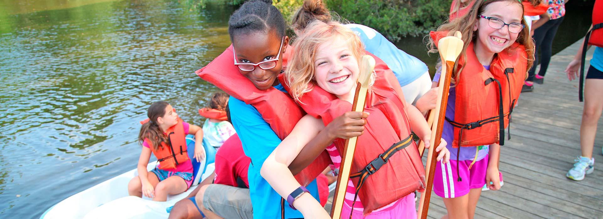 kids playing around kayaks