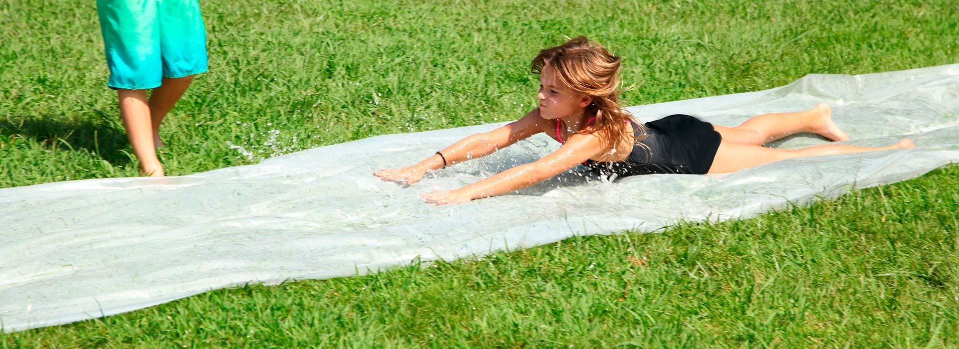 a girl running down a slip and slide