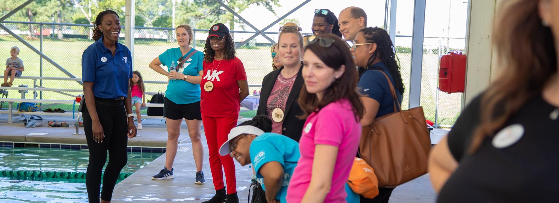 YMCA donors smile and chat while watching campers swim in the YMCA Camp Arrowhead pool