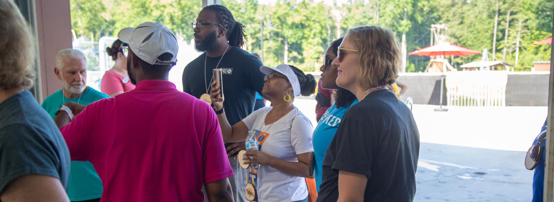 YMCA staff and donors have conversation while walking outside at YMCA at JT's Camp Grom