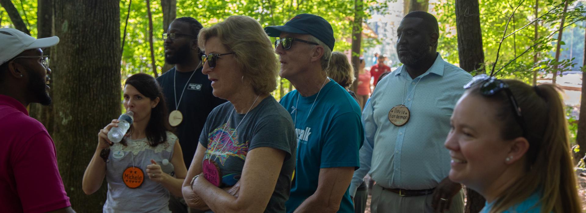 YMCA staff and donors have conversation while walking outside at YMCA at JT's Camp Grom