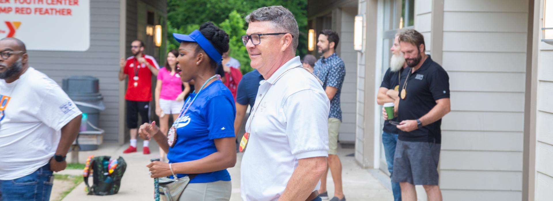 Camp staff and donors watch the activities at YMCA Camp Red Feather