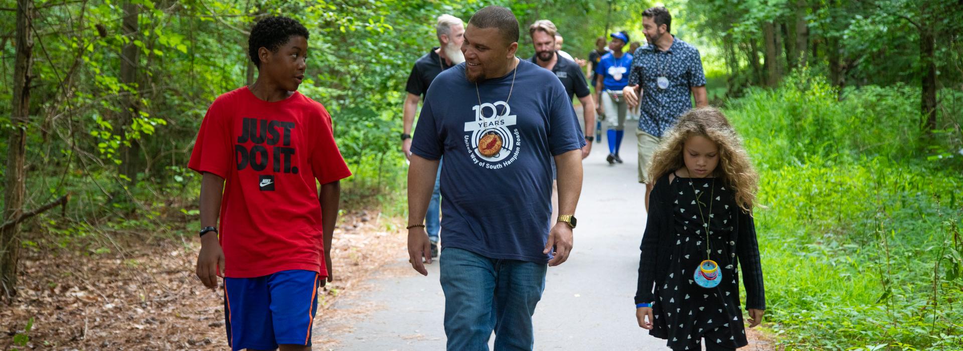 Camp donors walk along a path at YMCA Camp Red Feather