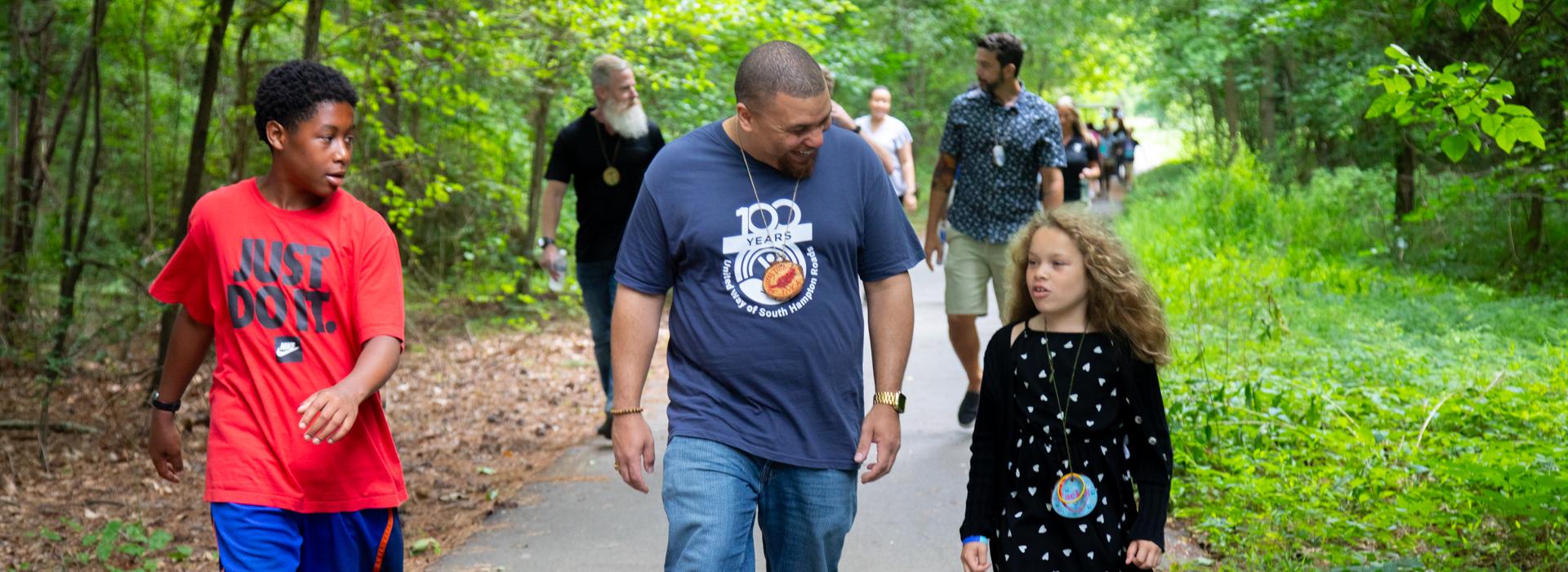 Camp donors walk along a path at YMCA Camp Red Feather