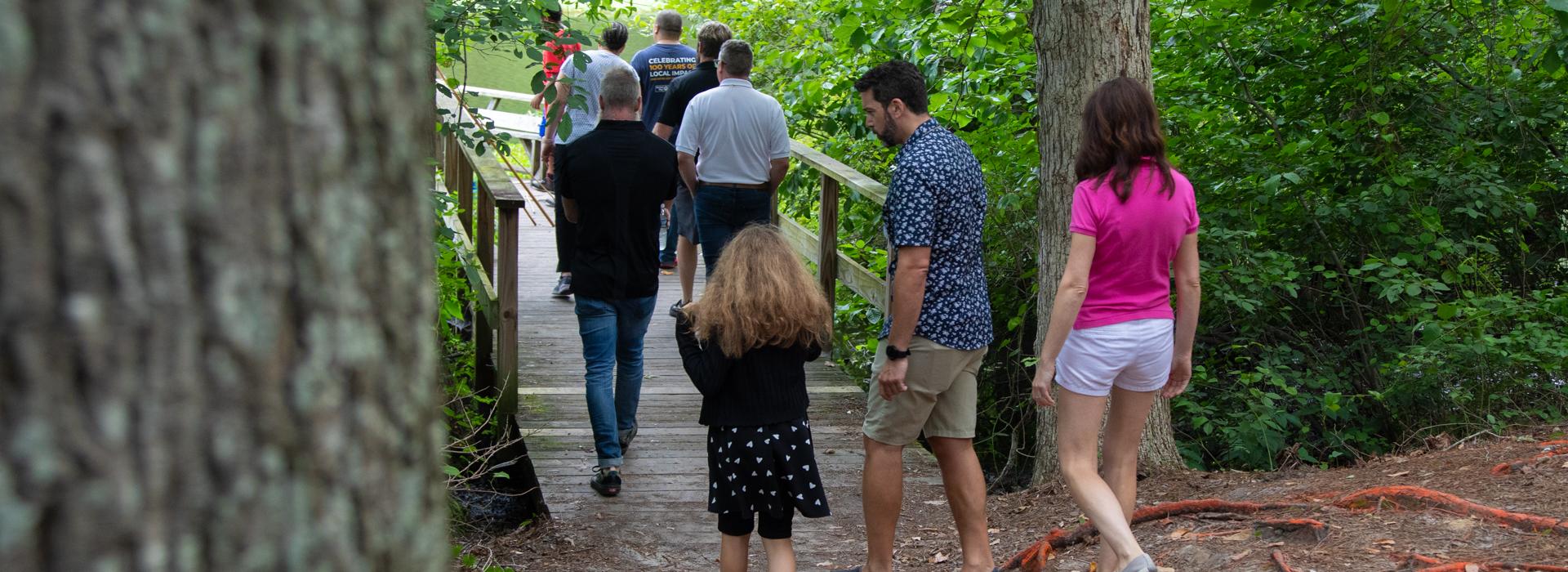Camp donors walk along the fishing pier at YMCA Camp Red Feather