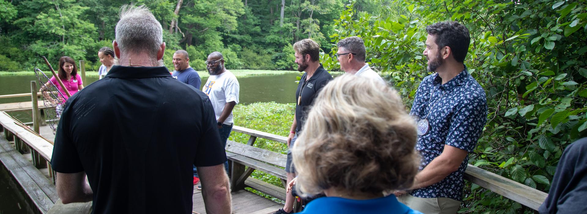 Camp donors gather on the fishing pier at YMCA Camp Red Feather