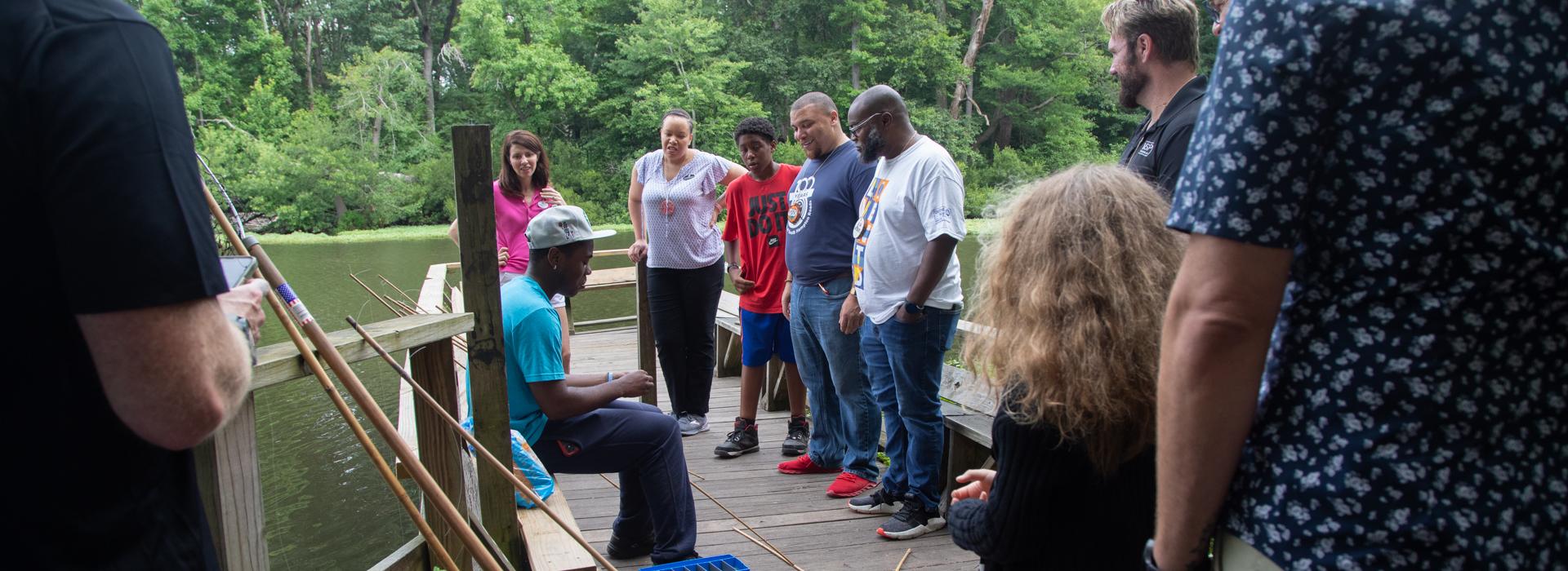 Camp donors gather on the fishing pier at YMCA Camp Red Feather