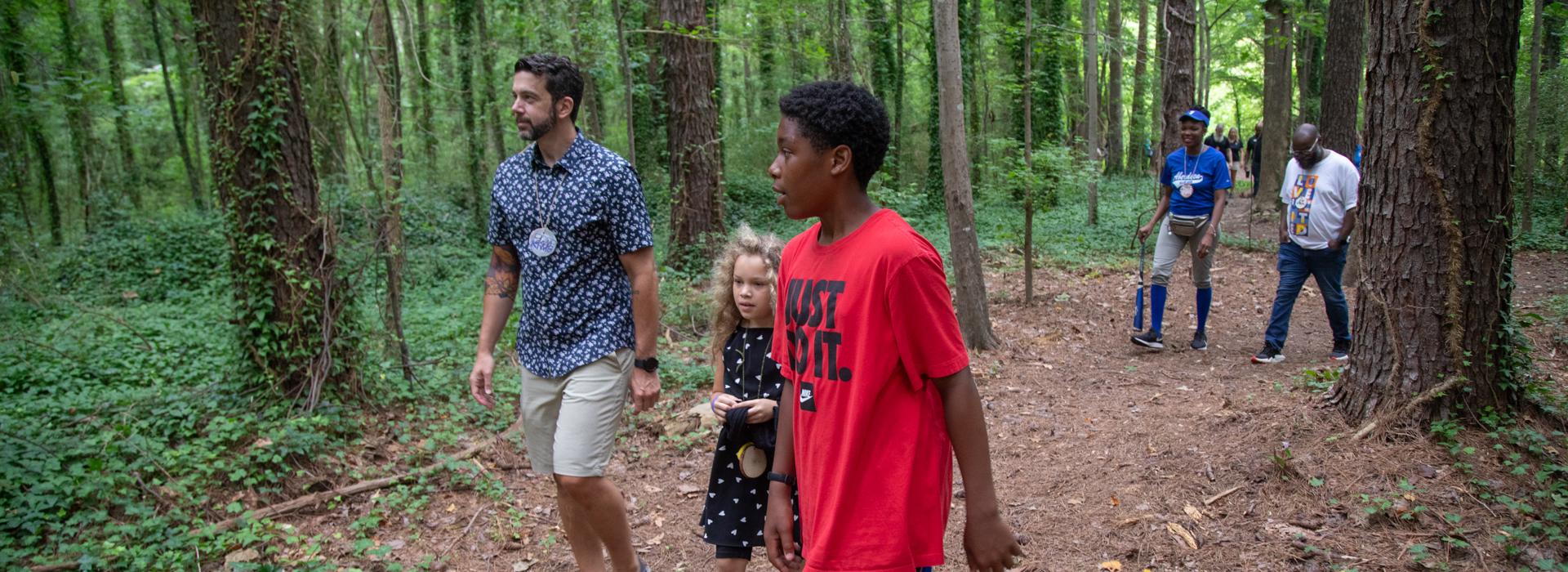 Camp donors walk along a trail at YMCA Camp Red Feather