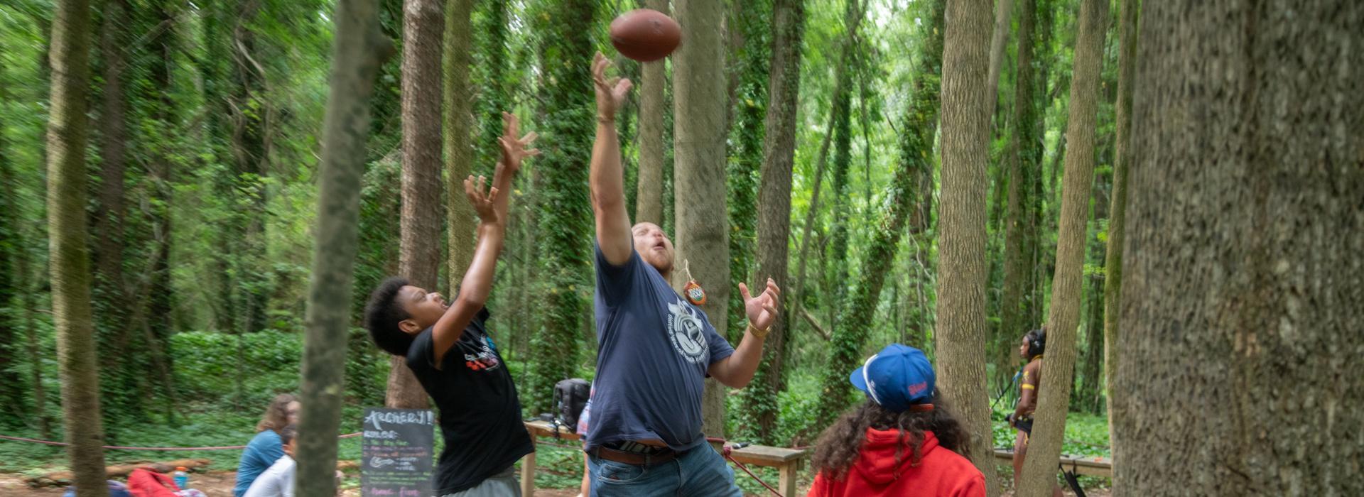 Camp donors play with a football at YMCA Camp Red Feather