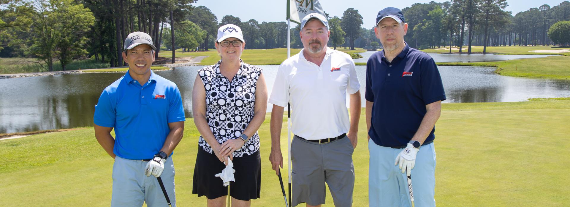 3 men and 1 woman golf team outside on a golf course at the YMCA Charity Golf Classic 2025