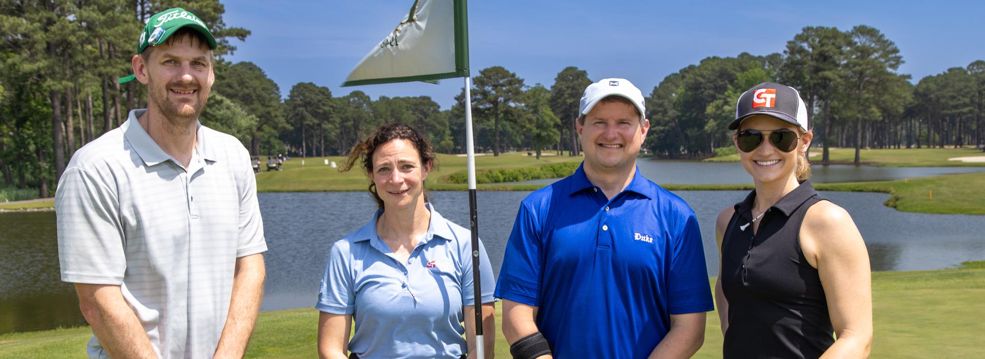 2 women and 2 men golf team outside on a golf course at the YMCA Charity Golf Classic 2025