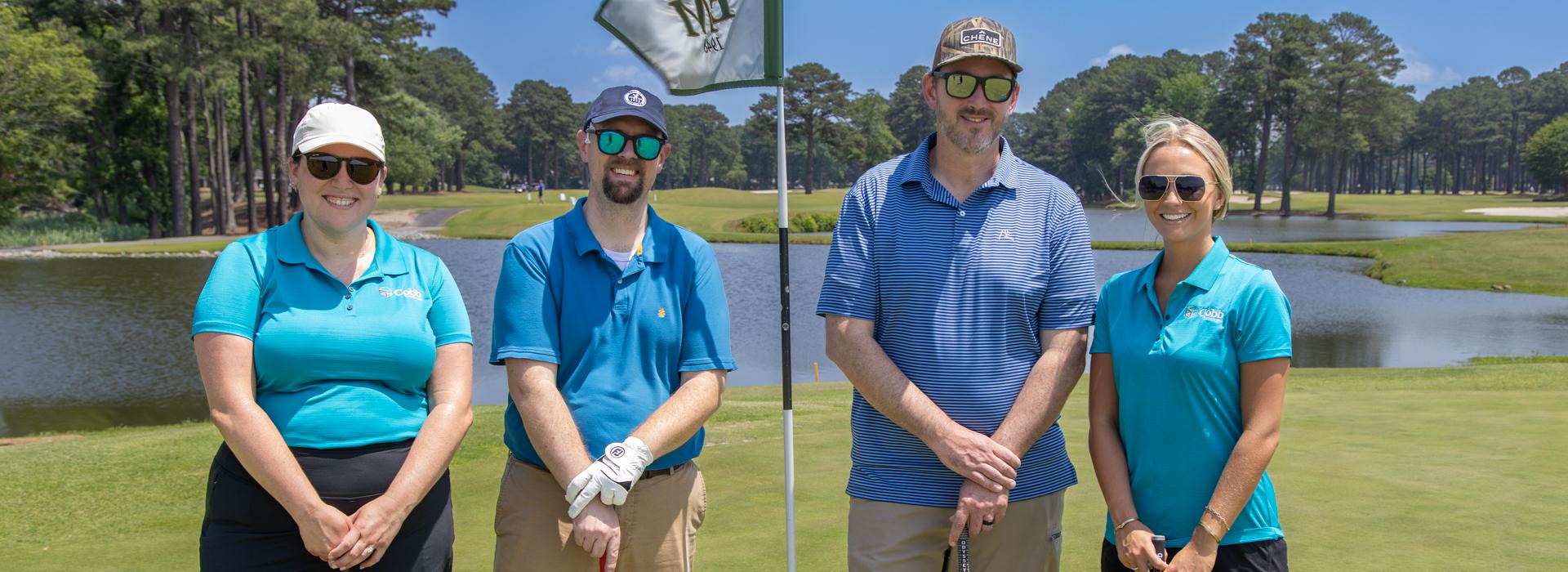 2 women and 2 men golf team outside on a golf course at the YMCA Charity Golf Classic 2025