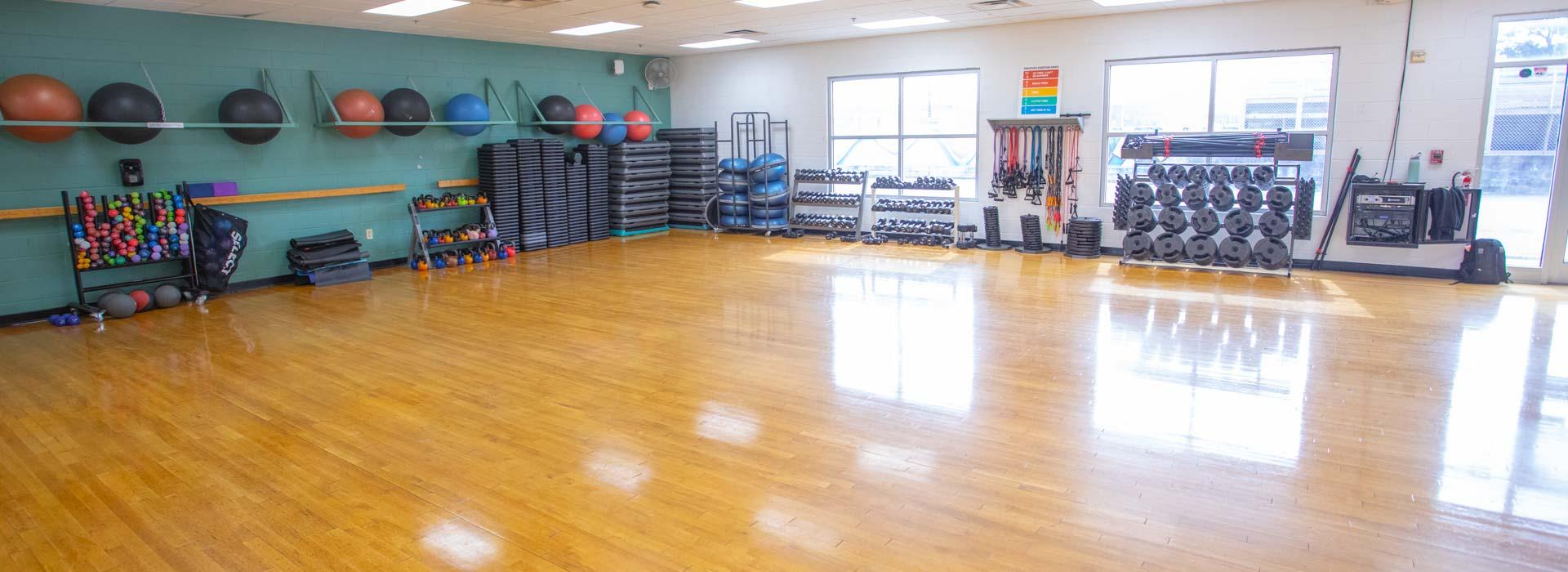 Group Exercise studio with wood floors and weight equipment at the Outer Banks Family YMCA