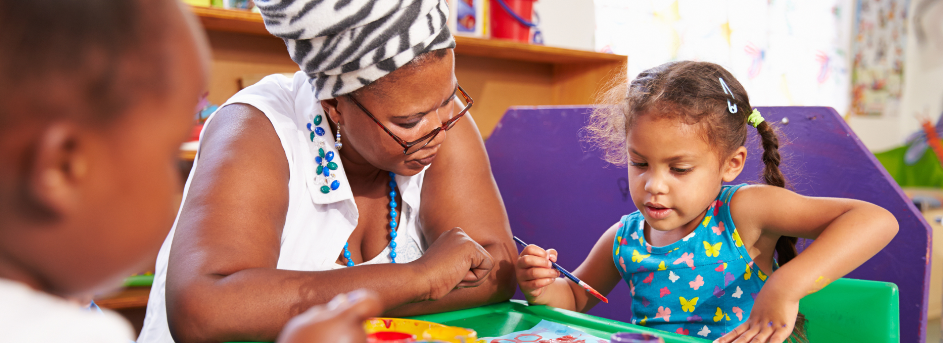 Child and adult painting together