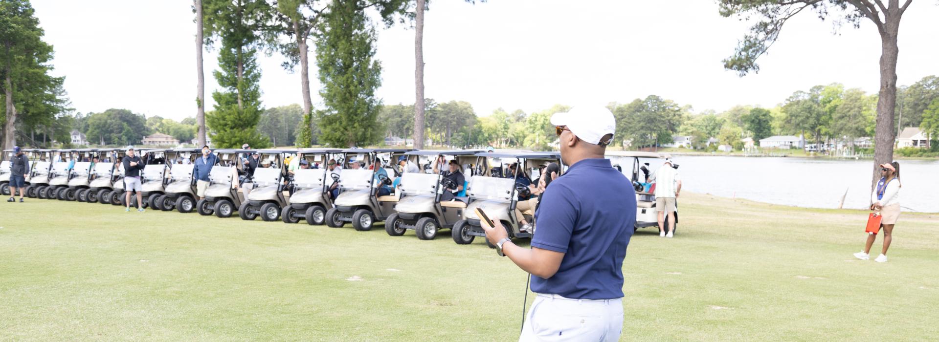 Man on the golf course in front of golf carts