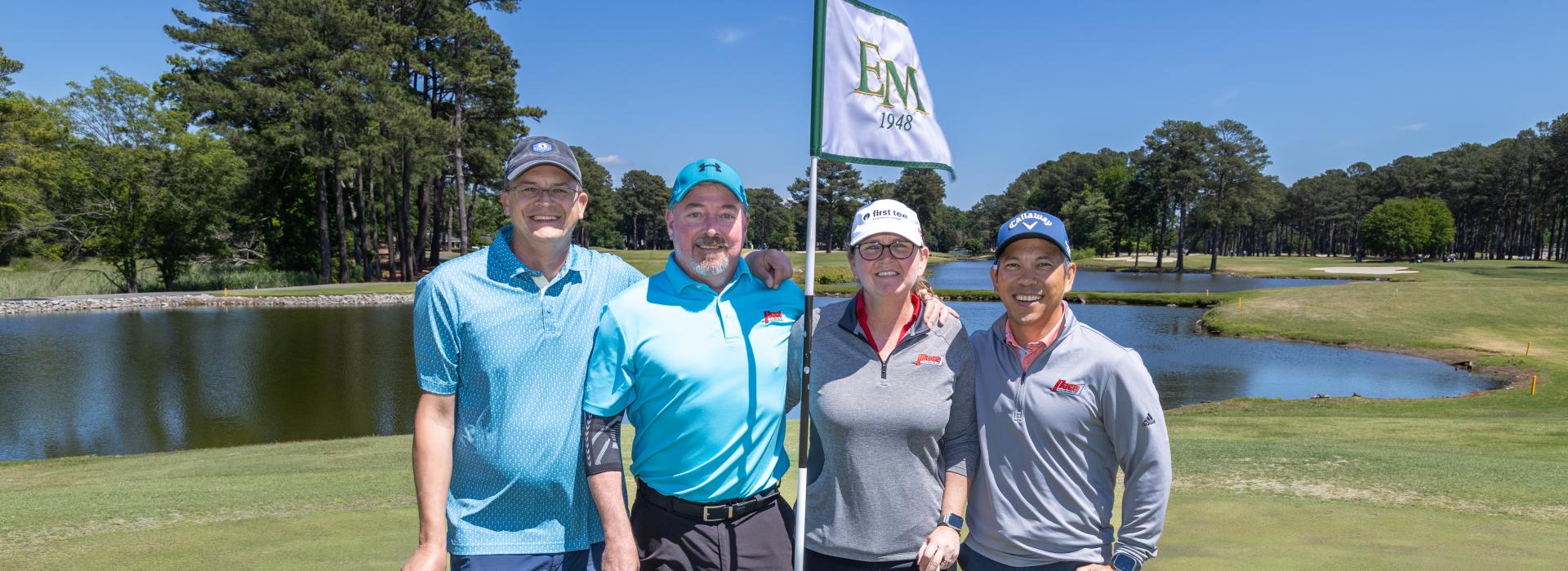 3 men and 1 woman on the golf green