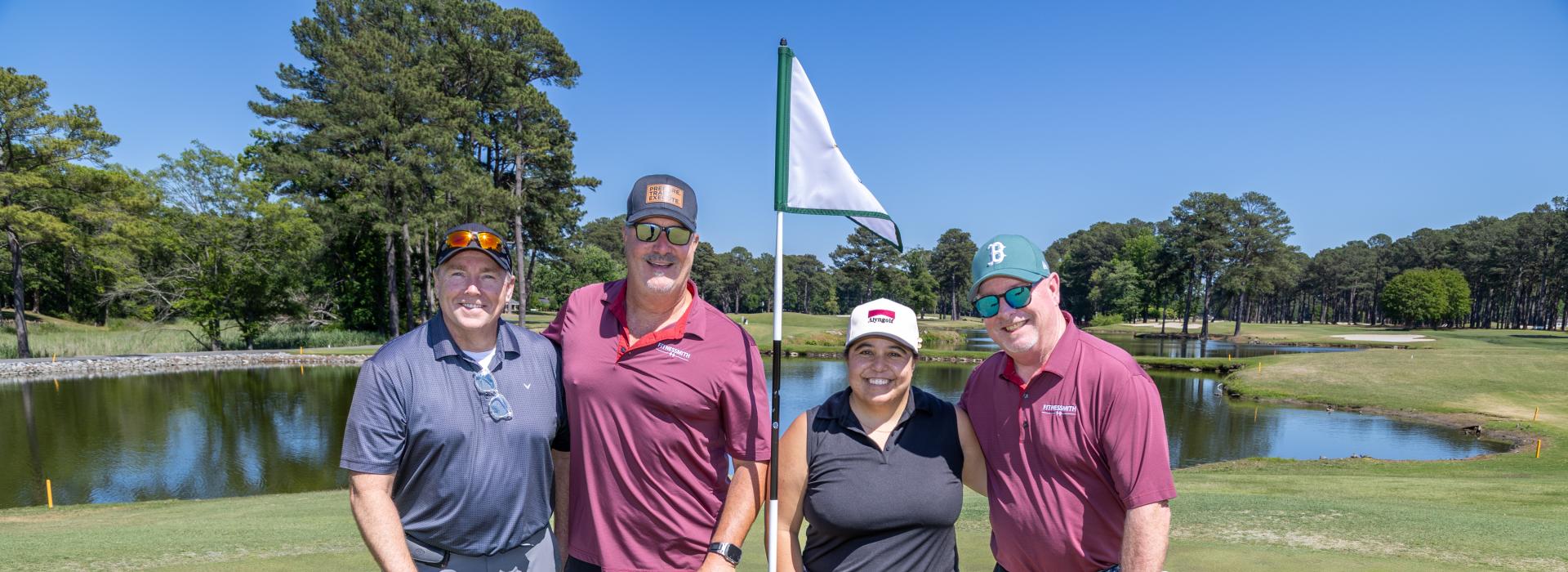 3 men and 1 woman on the golf green