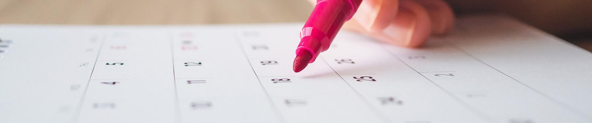 Marker pointing at date on a calendar