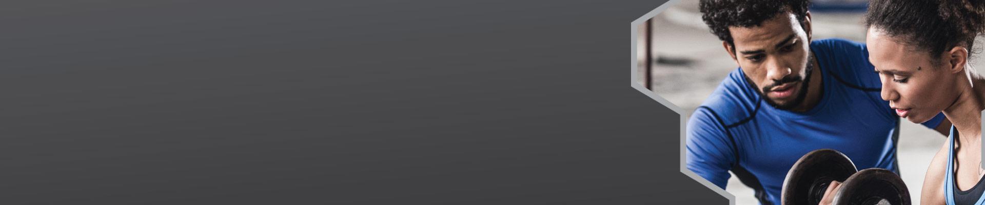 Personal Trainer helping client curl dumbbells