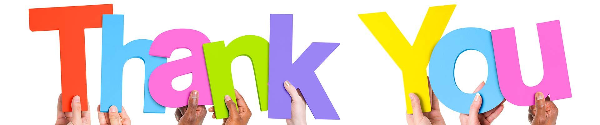 Hands holding cutout colorful letters that read &quot;Thank You&quot;