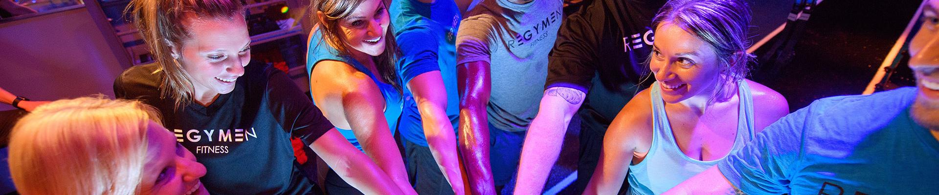 Regymen participants in a group huddle at the end of their workout