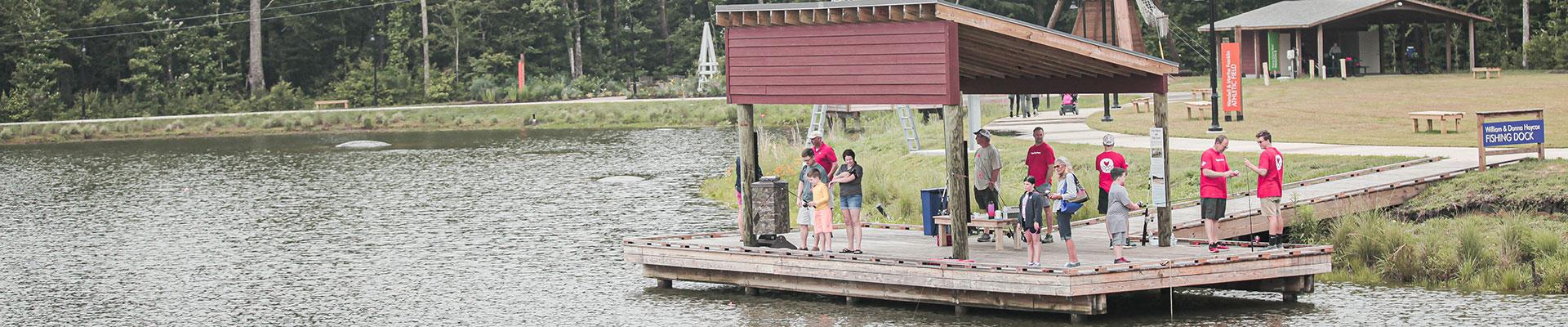 Photo shows a group on the fishing pier at YMCA JT's Camp Grom