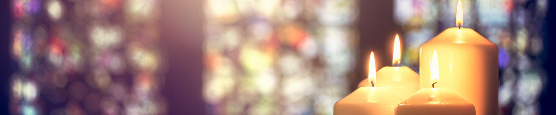 Candles burning against stained glass background