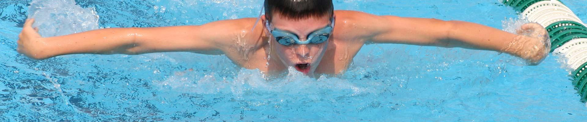 Young swimmer swimming the butterfly stroke in the pool