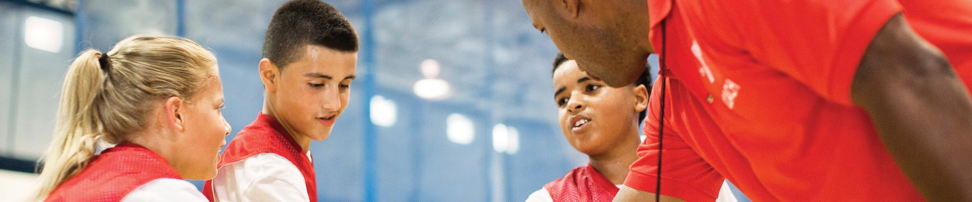 Coach with basketball players in a huddle