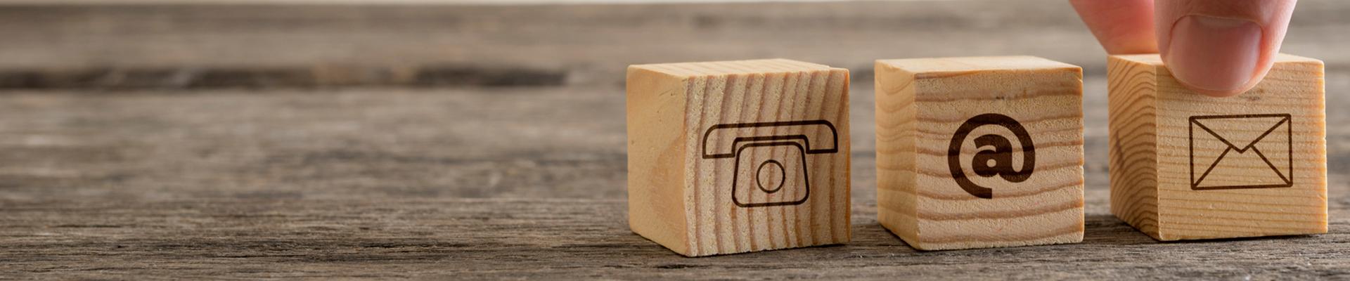 wooden blocks with phone, @ sign and envelope icons