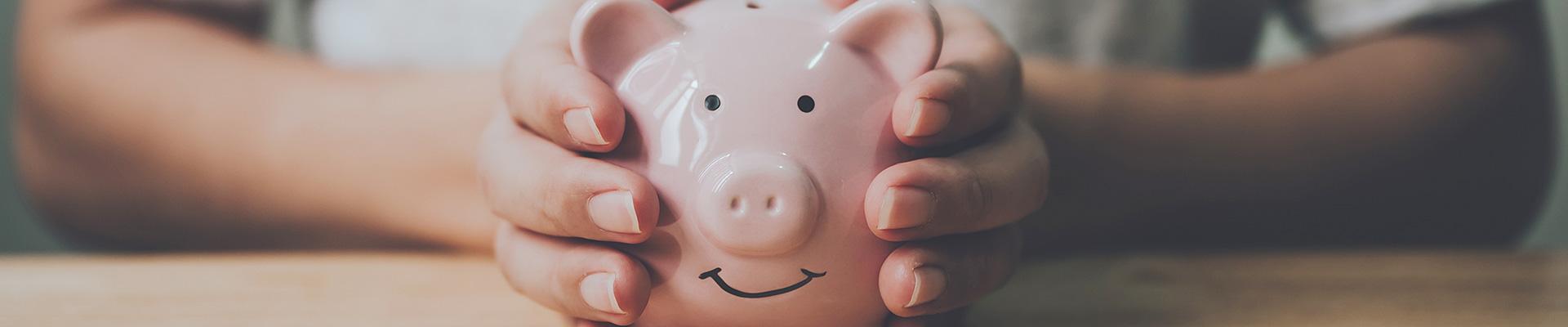 Hands on a ceramic piggy bank