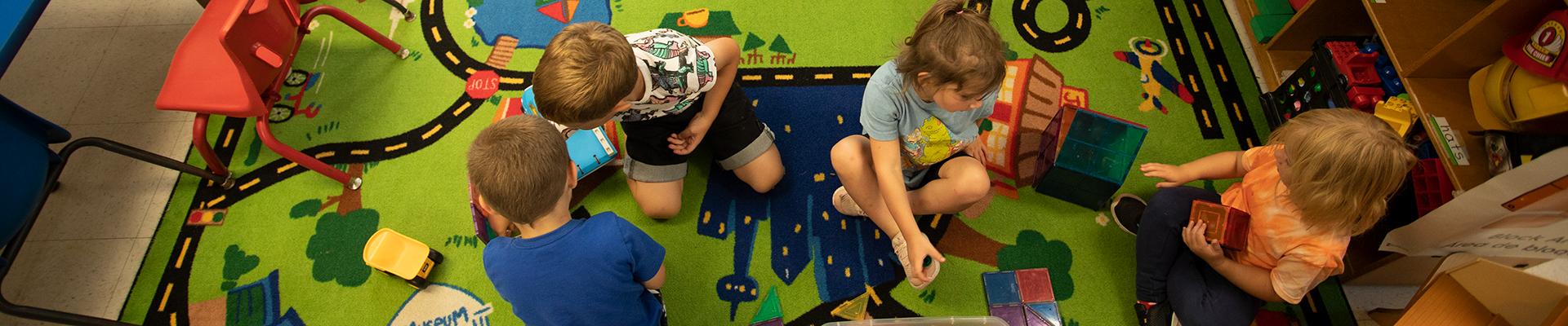 Overhead shot of YMCA preschoolers playing on a road rug