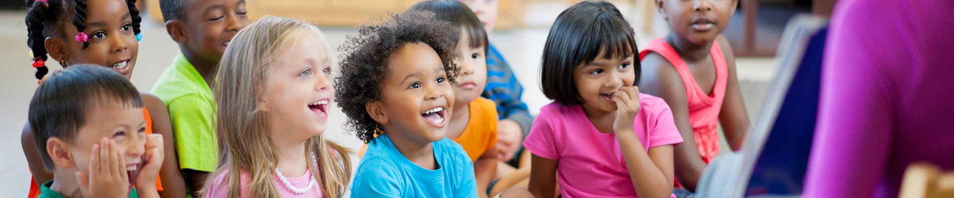 Group of preschoolers laughing during story time