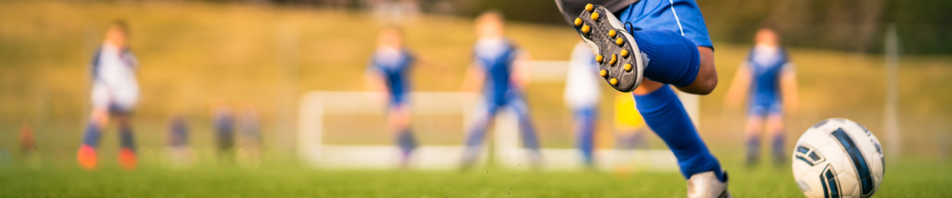 Kid playing soccer in local park