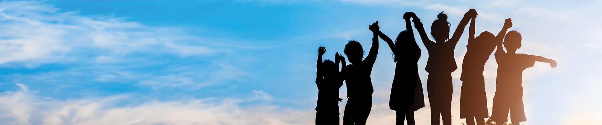 YMCA kids standing together with arms raised