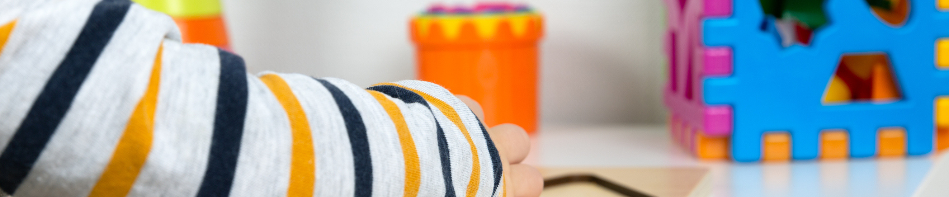 a child's hand doing a puzzle at school