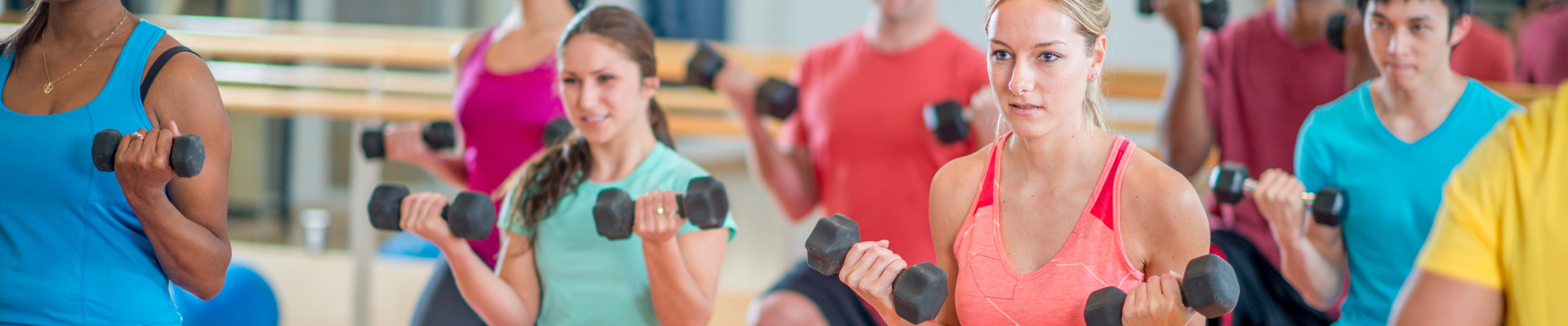 Indoor group fitness class with people lifting hand weights