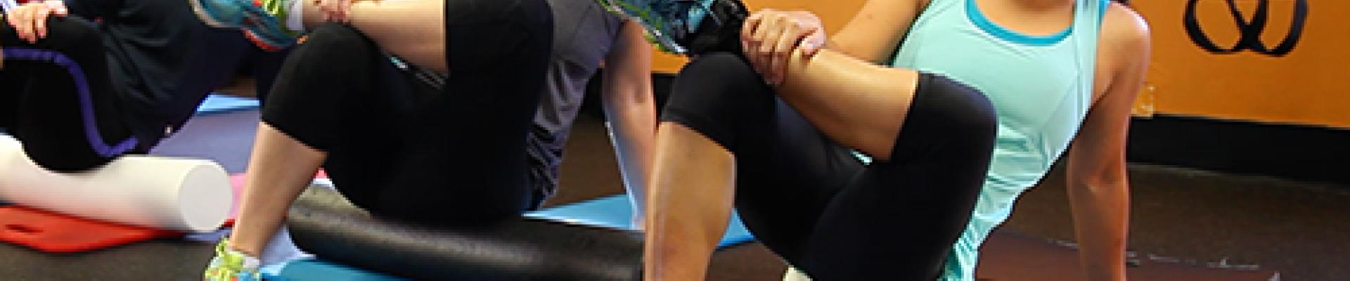 women stretching on fitness rollers in a gym studio