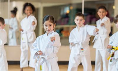 A group of young martial artists wearing gis and posing for the camera