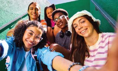 Teens in stairwell taking group selfie