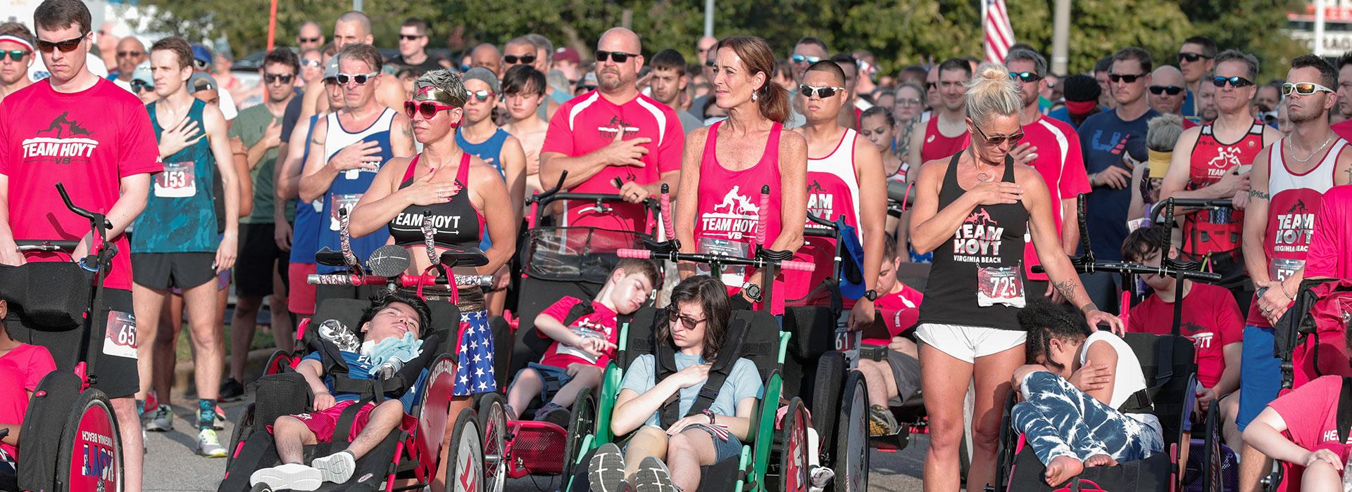 Runners gather with hands on heart at the beginning of the 35th annual Independence Day Run