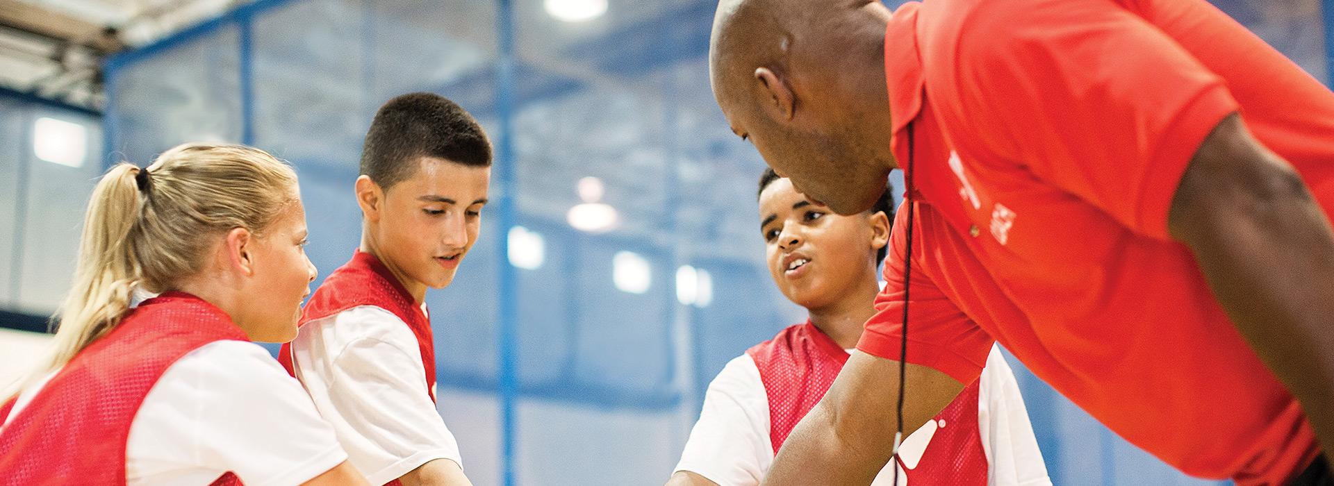 Basketball coach in huddle with team
