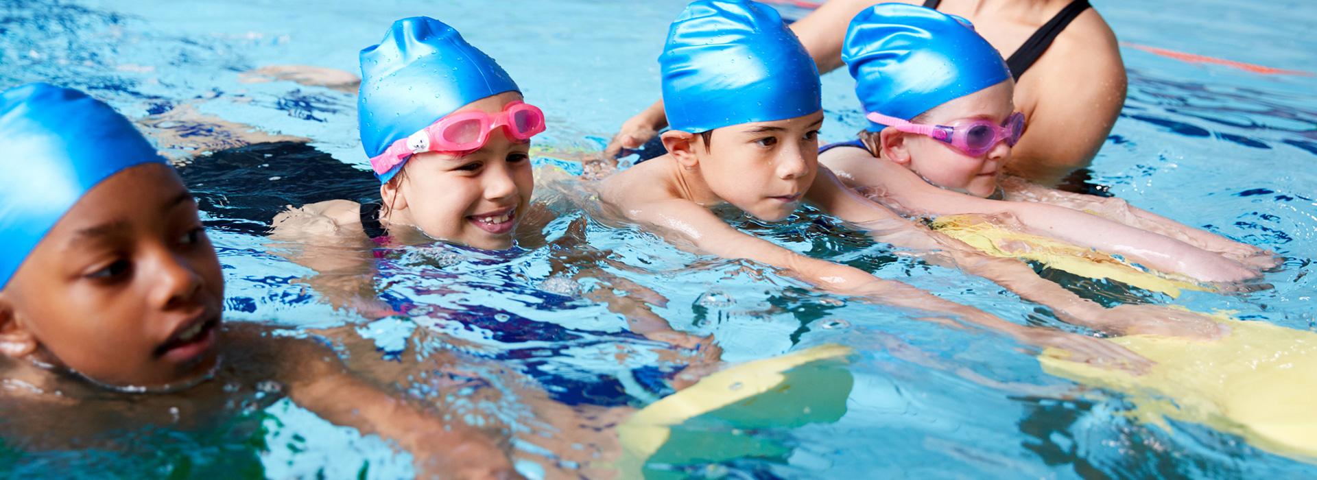 Group of young children in swim lesson using kickboards