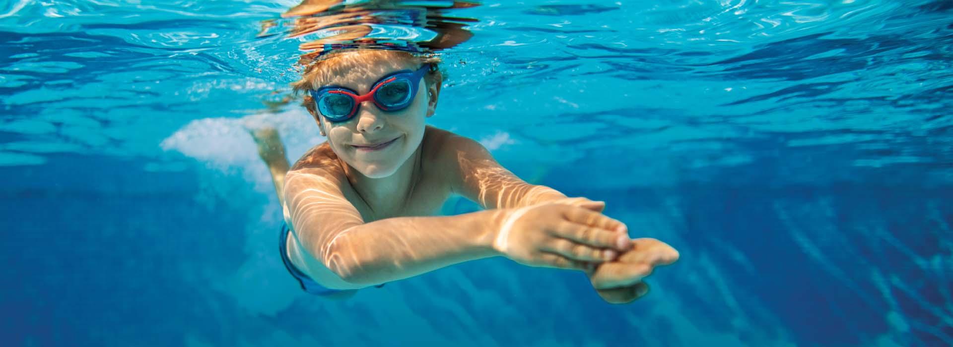 Child swimming underwater in a pool
